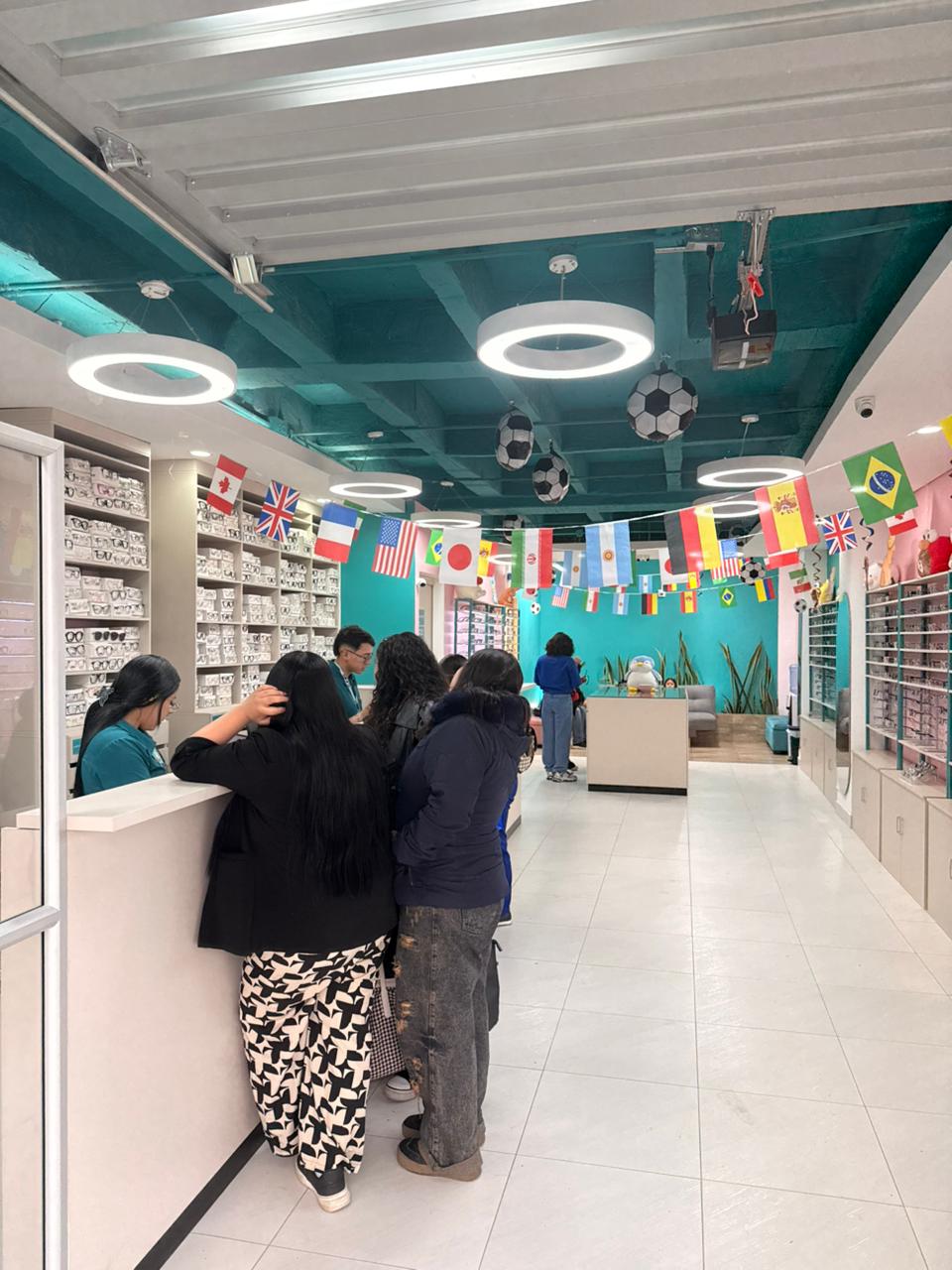 Interior de Óptica Naratodo Tunja: local amplio con más de 300 referencias de monturas exhibidas, techo teal y sala de estar